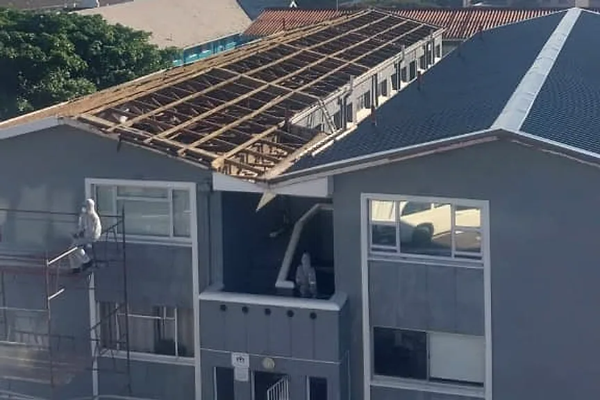 A two-storey commercial building with its old roof stripped back to the timbers during a re-roof