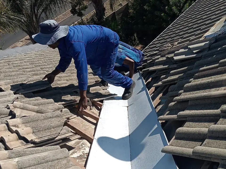 A Roof Direct roofer fitting a new valley flashing between concrete roof tiles